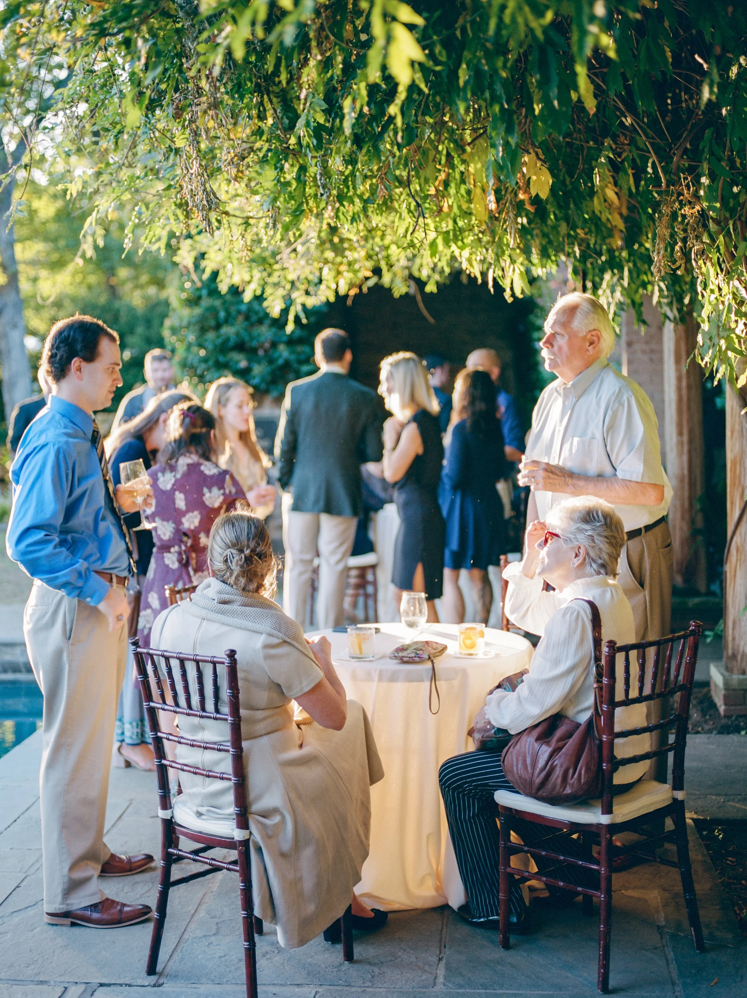 Wedding guests mingling during cocktail hour on the pool terrace at Goodstone Inn