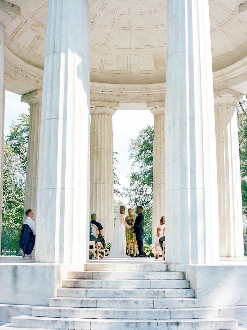 Bride and groom during intimate wedding ceremony at DC War Memorial on the National Mall in Washington DC.