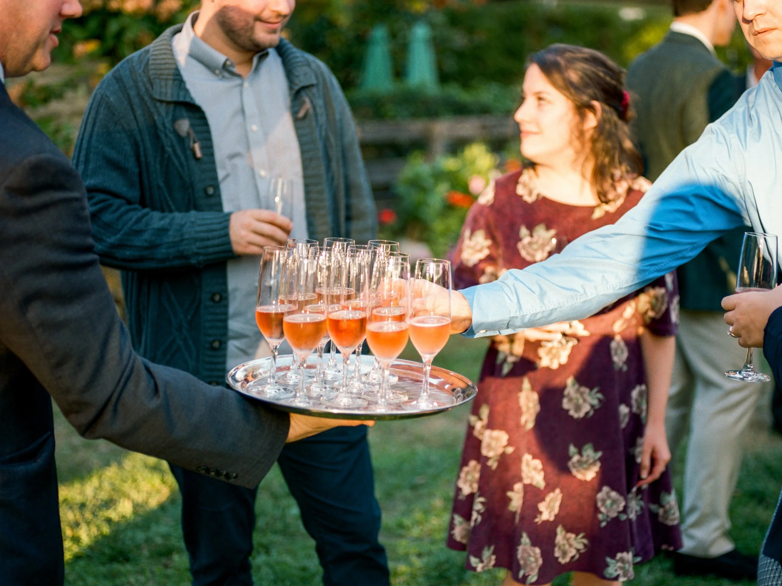 Wedding guests mingling during cocktail hour on the pool terrace at Goodstone Inn
