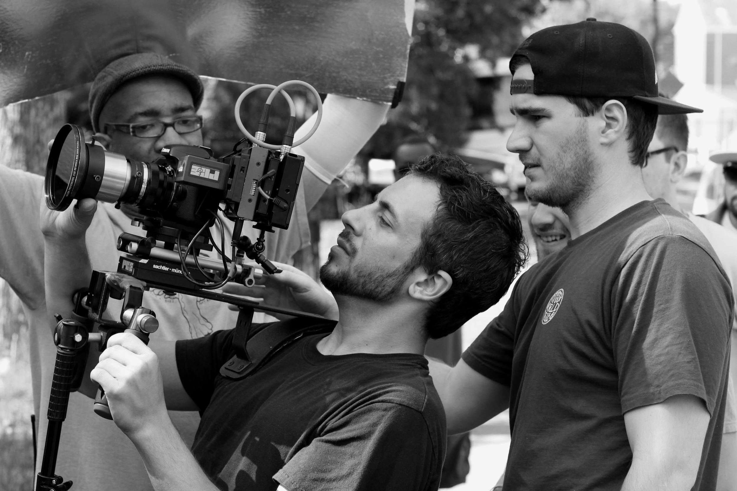 Filmmakers on a film set preparing a shot with a camera and crew members helping.
