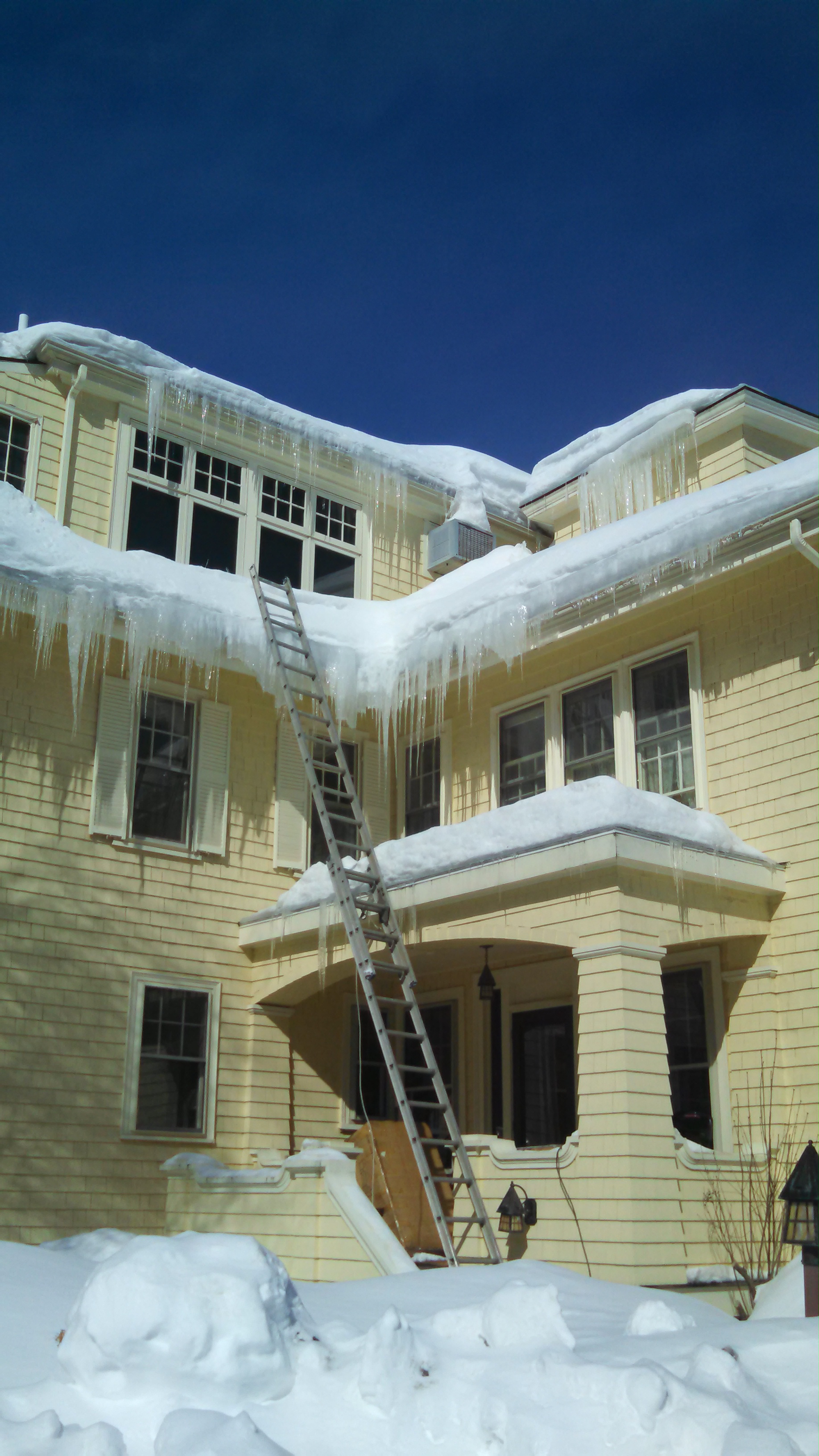 The larger the overhang of the roof, the more time you have to react. These icicles look problematic but actually they're not doing any major harm to the roof.