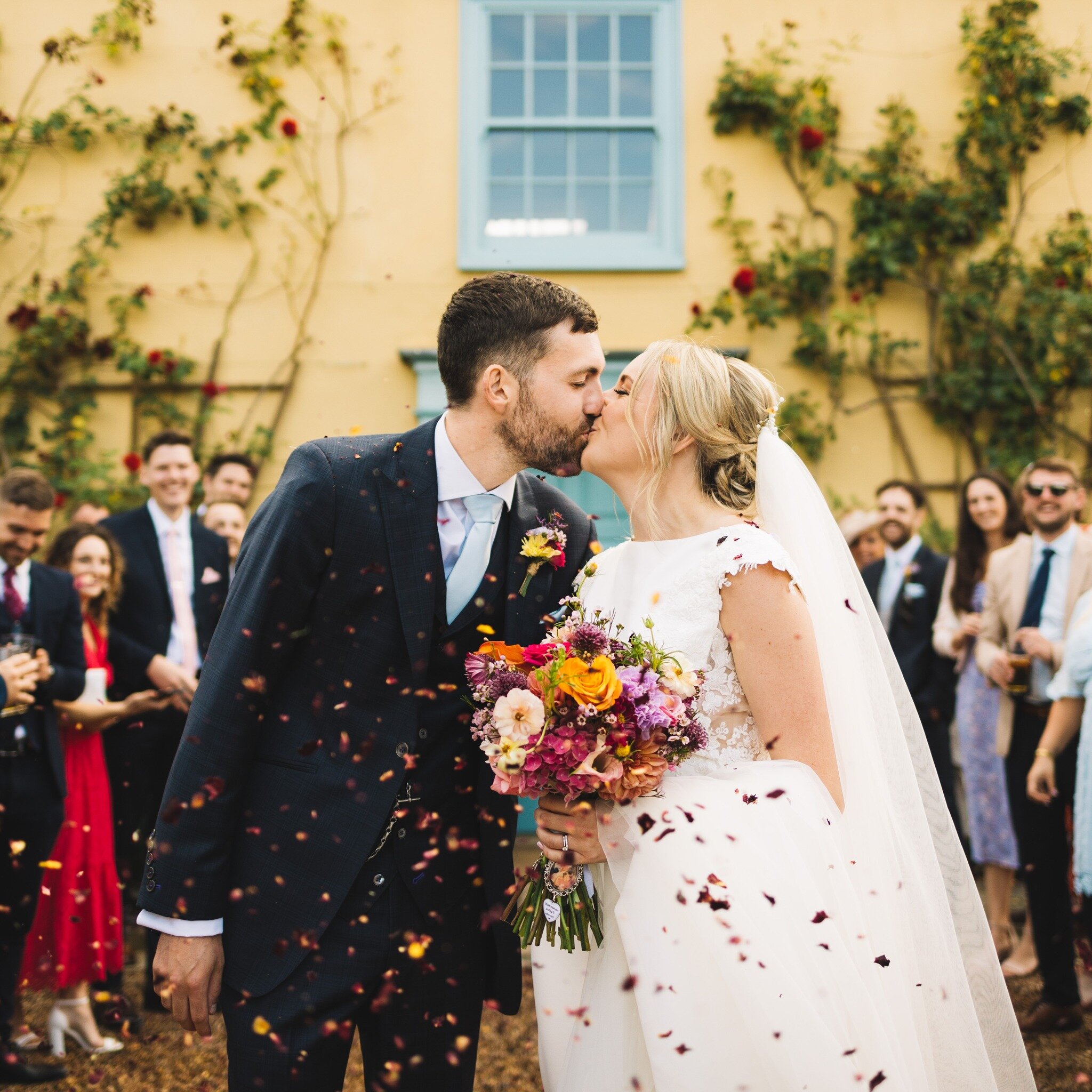 A colourful confetti moment with Laura &amp; Marcus in front of the blue doors.. the classic South Farm shot! 💛

Venue: @southfarm1 
Dress: @harveysoframsey 
Suit: @sousterandhicks 
Flowers: @willowandwreathflorist
Hair: @bellarosehairdesign 
Makeup