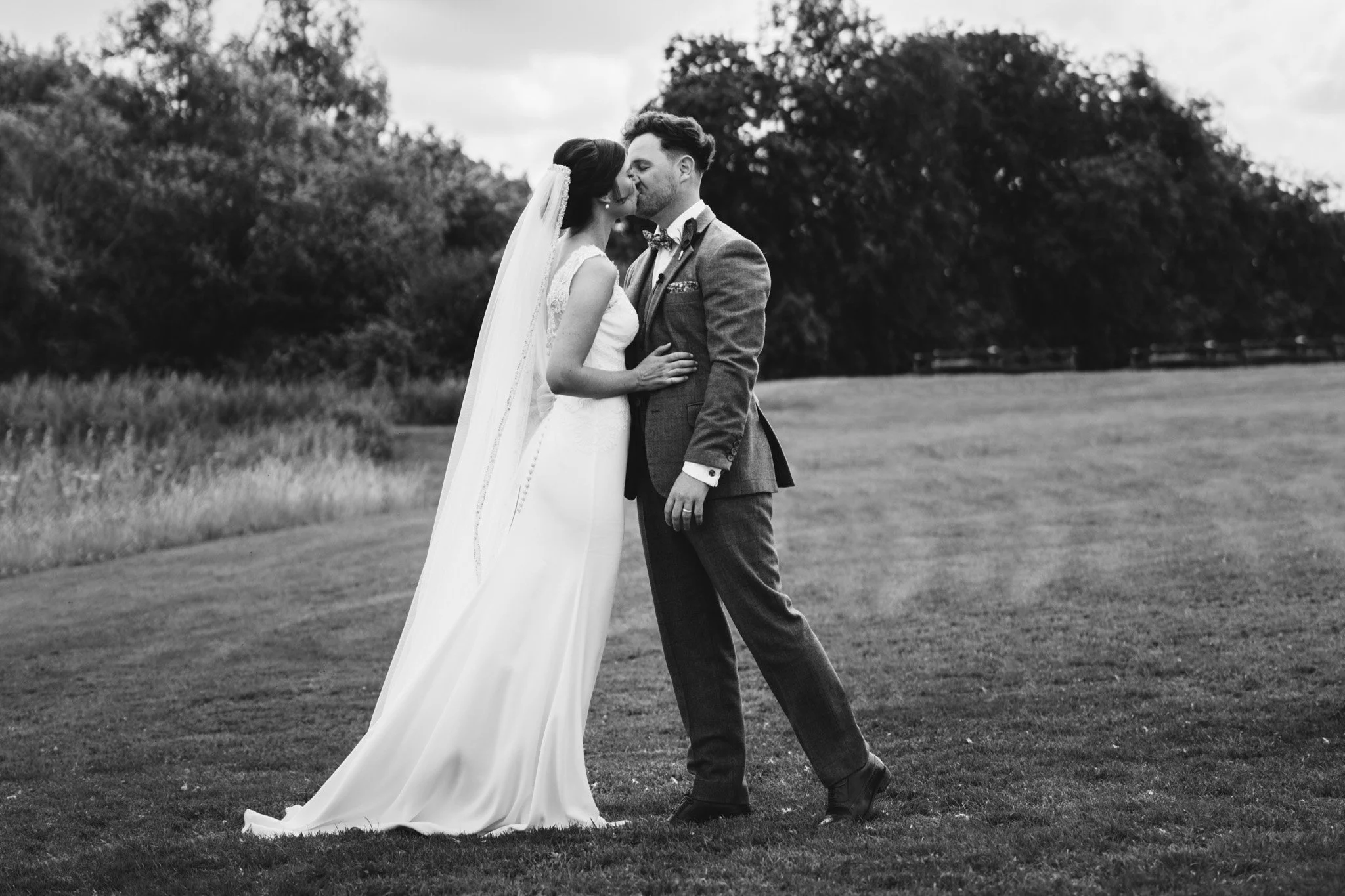 The newlyweds share their first kiss at the end of their outdoor wedding ceremony at Newton Park Farm.