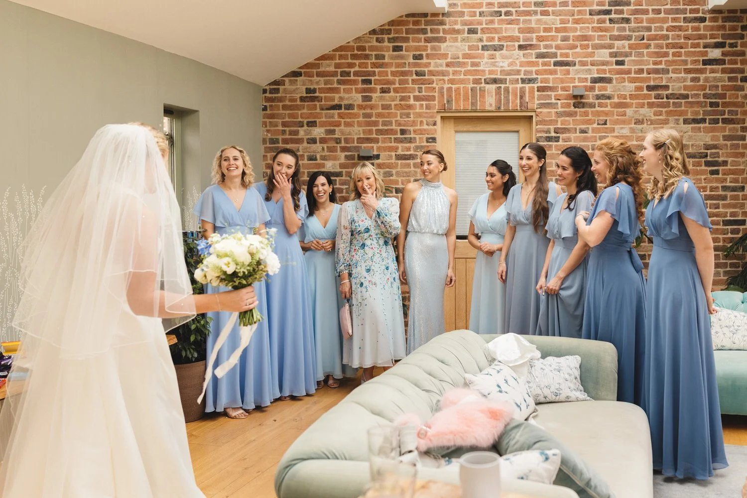 In the Fen Bridge Farm B&B, nine bridesmaids and the mother of the bride are emotional as the bride appears in her dress and veil for the first time.