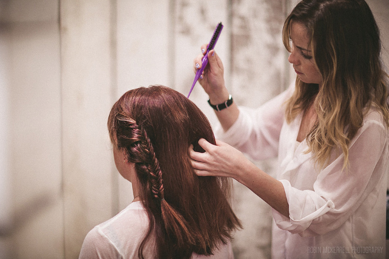 Samantha works two small fishtail braids, tying them back into a small french twist.