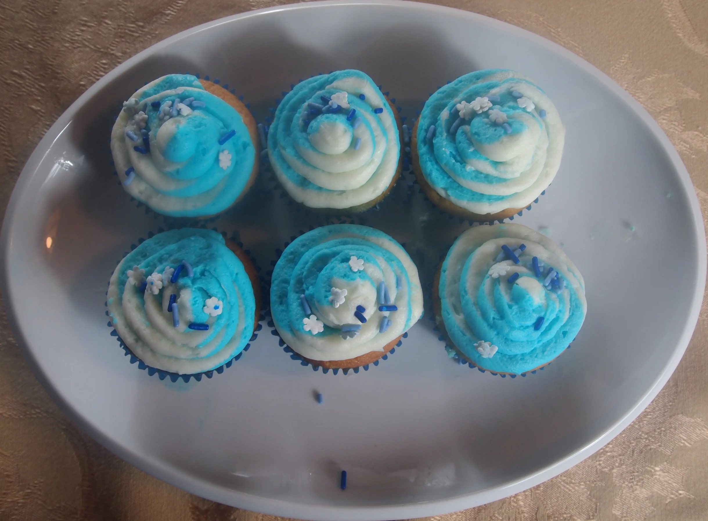 Vanilla cupcakes - iced with a swirl of white and winter-themed blue.