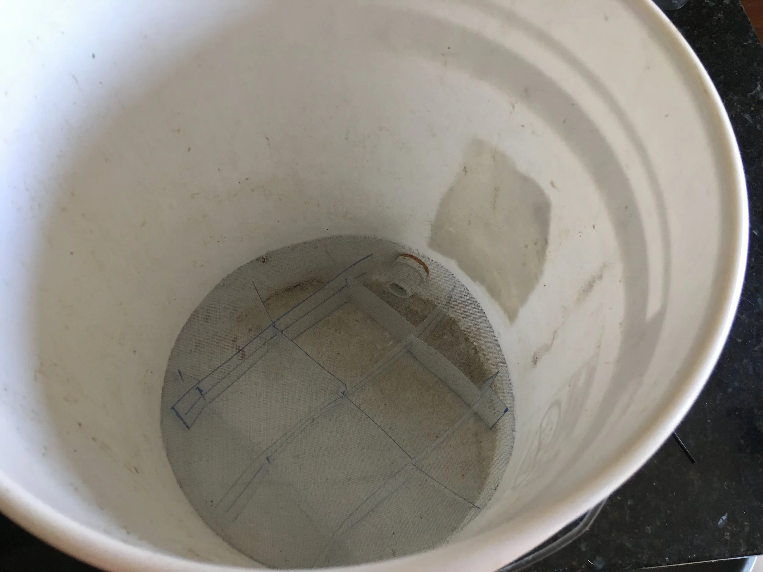 Kind of hard to see, but the grid has been placed on the bottom of the bucket (the spigot fits between the walls of the grid). The window mesh is then placed on top of the grid to prevent the worms from falling down into the liquid.