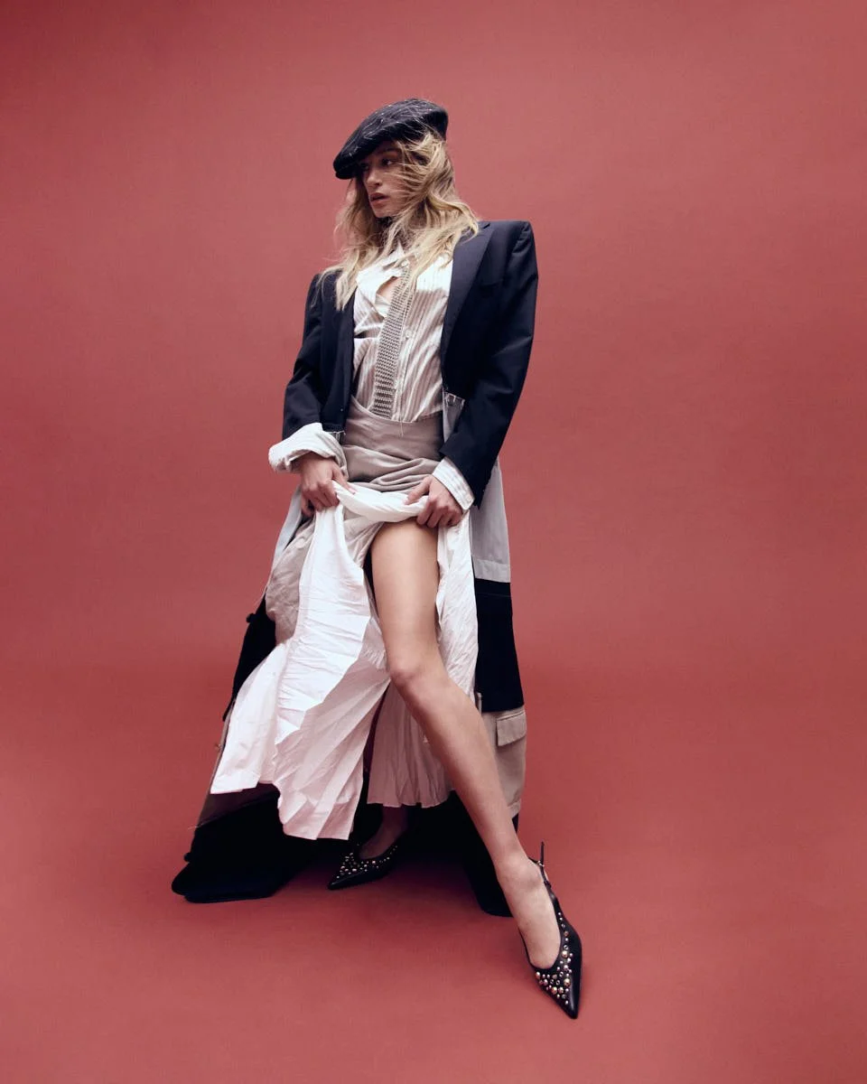 FRANCESKA NUREDINI Dancing Tides for LE MILE Magazine wearing Franceska wears a coat by DEAD COUTURE ICONS, a shirt by GRIFONI, skirts by MEIMEIJ and YALI, shoes by APEPAZZA, a hat by DOLCE&GABBANA, and jewellery by LAG WORLD