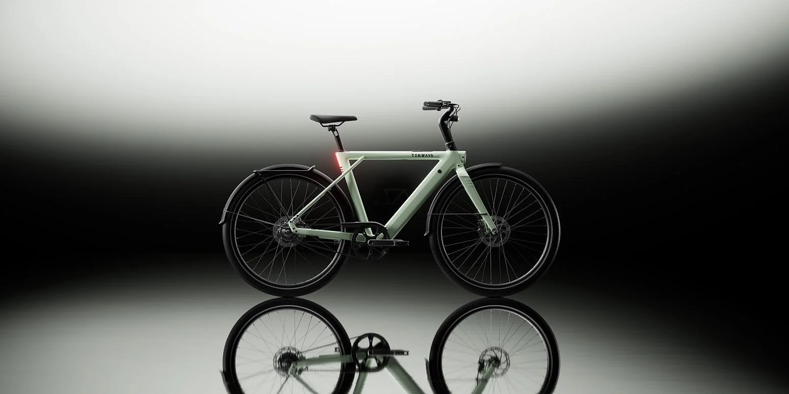 TENWAYS CGO 009 e-bike in pale green shown in profile against a dark studio background with a reflective floor
