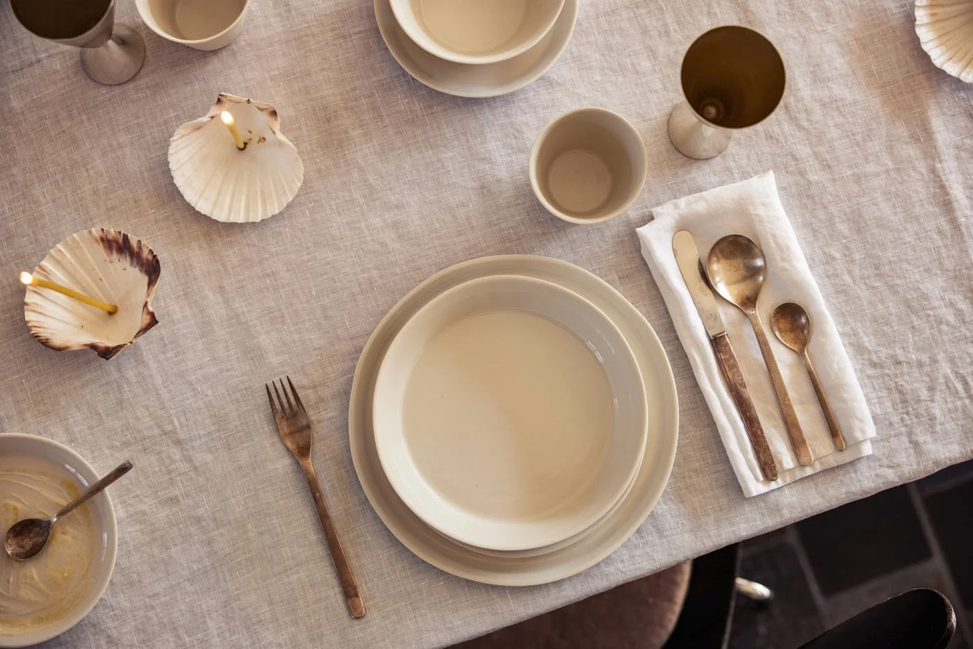 onomao Pura collection in White with porcelain plates, bowls and cups arranged on a linen table setting, LE MILE Magazine.