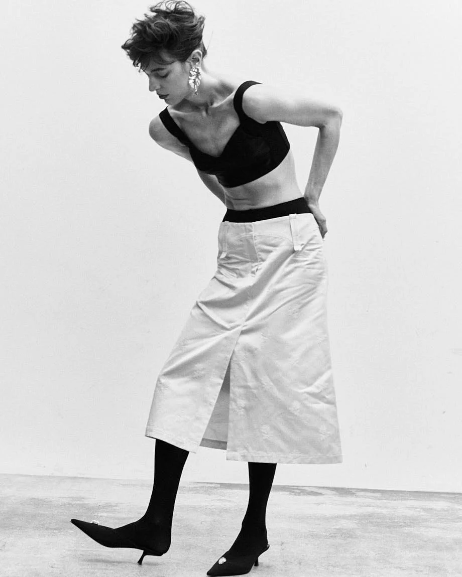 CATERINA DEORDIEVA LE MILE Magazine Antonio Grotti editorial SS26 womenswear Caterina wears top by DOLCE&GABBANA, skirt by TORY BURCH, shoes by GIUSEPPE ZANOTTI, jewellery by VOODOO JEWELS and tights by CALZEDONIA