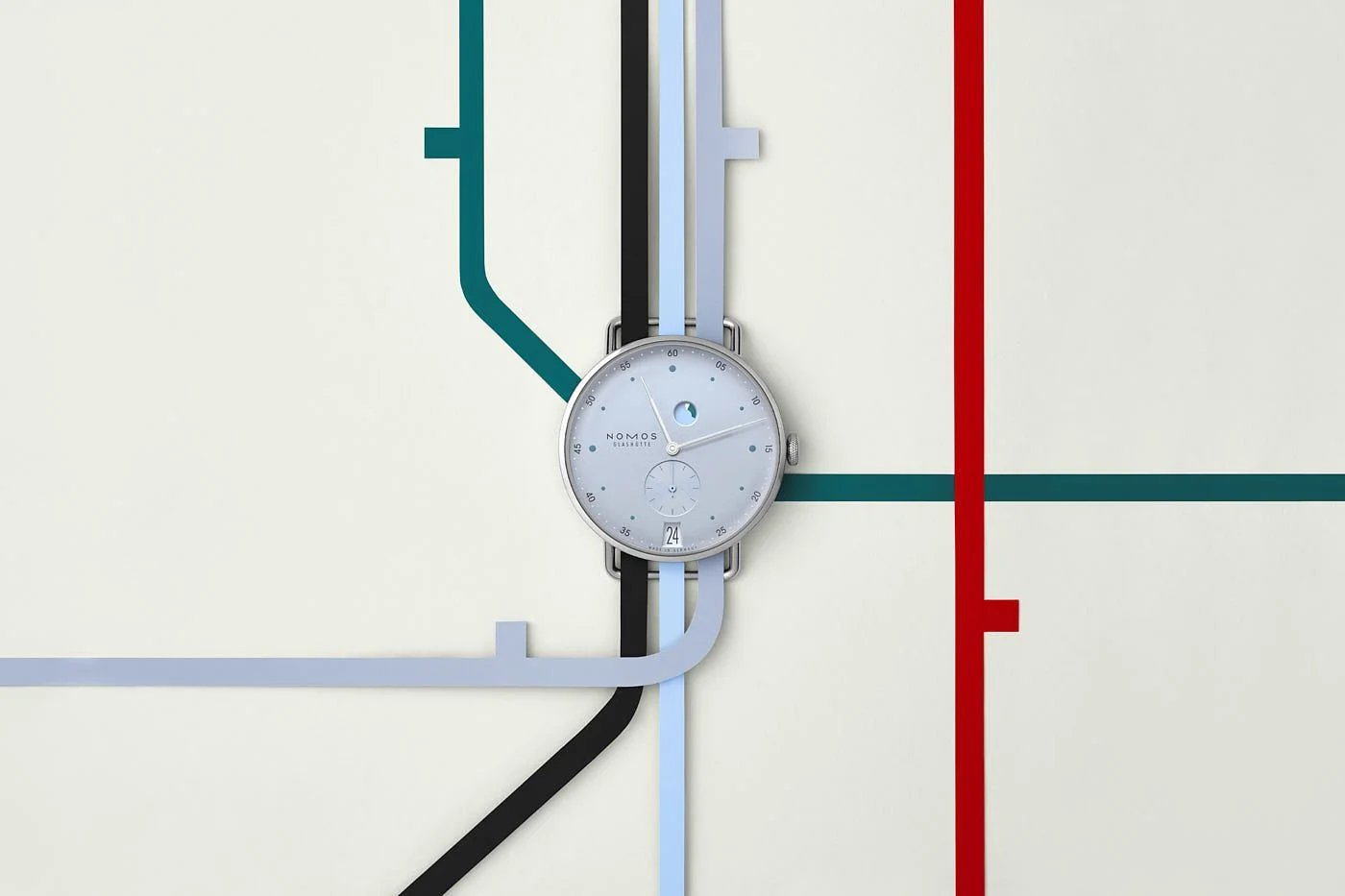 NOMOS Glashütte Metro date power reserve ice blue watch surrounded by coloured lines resembling a subway map on a cream background