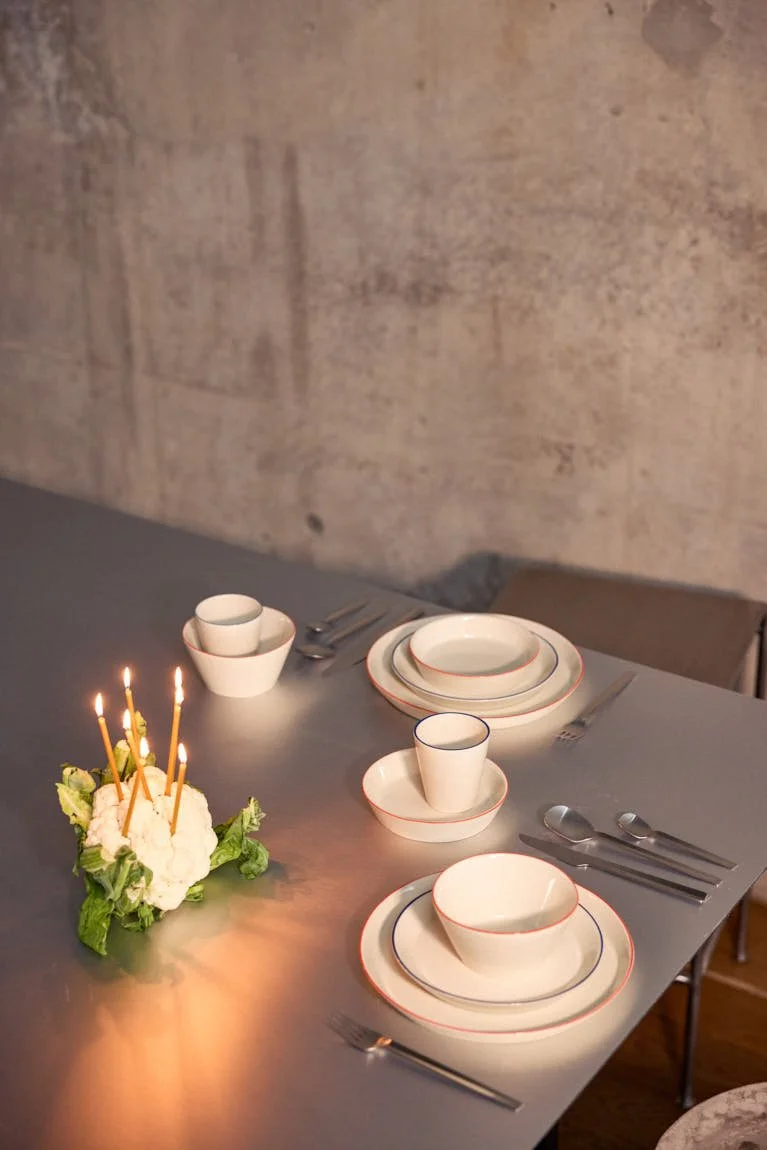 onomao Aberta collection arranged as an everyday table setting with hand-painted orange and blue details on stoneware, LE MILE Magazine.