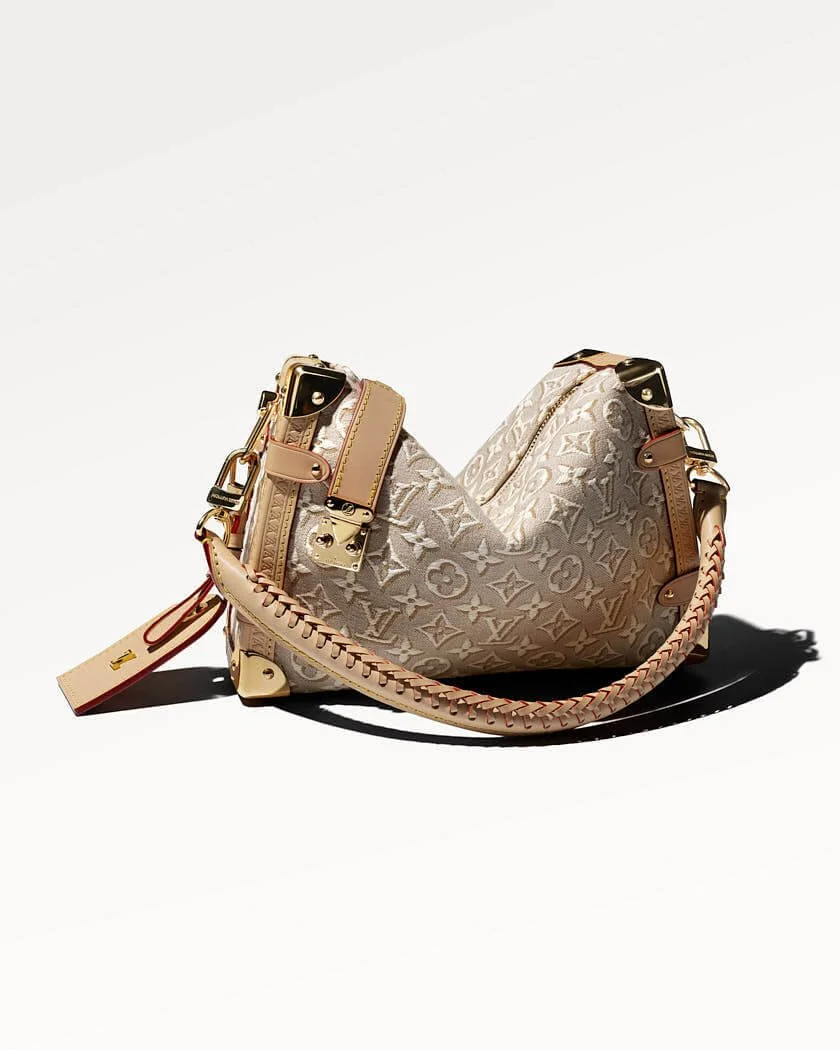 Louis Vuitton Side Trunk bag in Monogram Emblème Peuplier jacquard with natural leather trims, braided shoulder strap, gold-tone hardware, reinforced corners and luggage tag on a white background