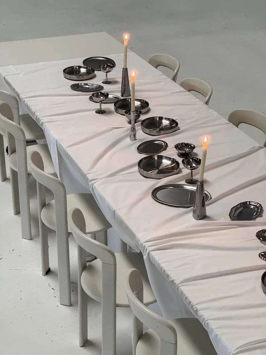 LE MILE Magazine SOOS Atelier Stainless Steel Tableware A table setting with stainless steel plates, bowls, trays and serving pieces from the SOOS Atelier collection. Photography by Tess Letort.