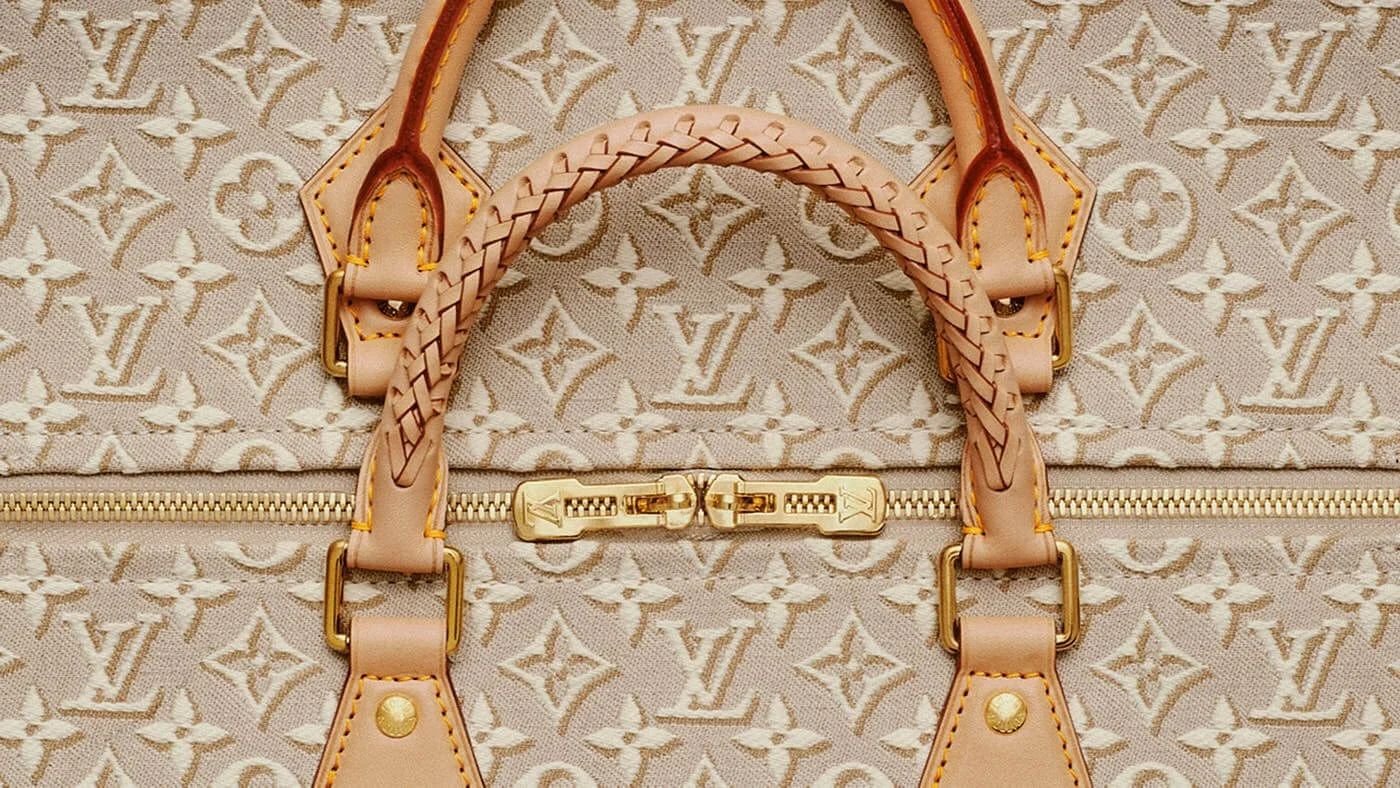 Close-up of the Louis Vuitton Speedy 30 Soft in Monogram Emblème Peuplier jacquard, showing braided leather handles, gold-tone zipper hardware, natural leather trims and textured Monogram canvas during assembly