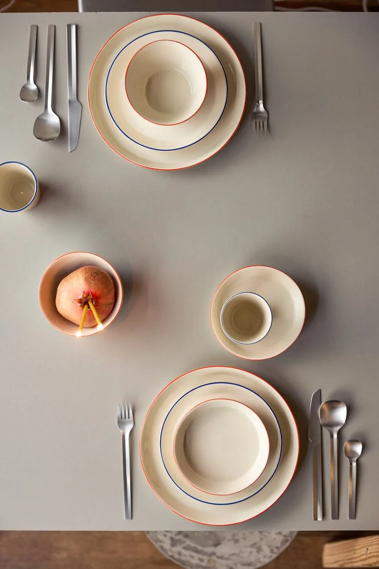 onomao Aberta collection tableware with conical stoneware plates, bowls and cups finished with hand-painted blue and orange rims, LE MILE Magazine.
