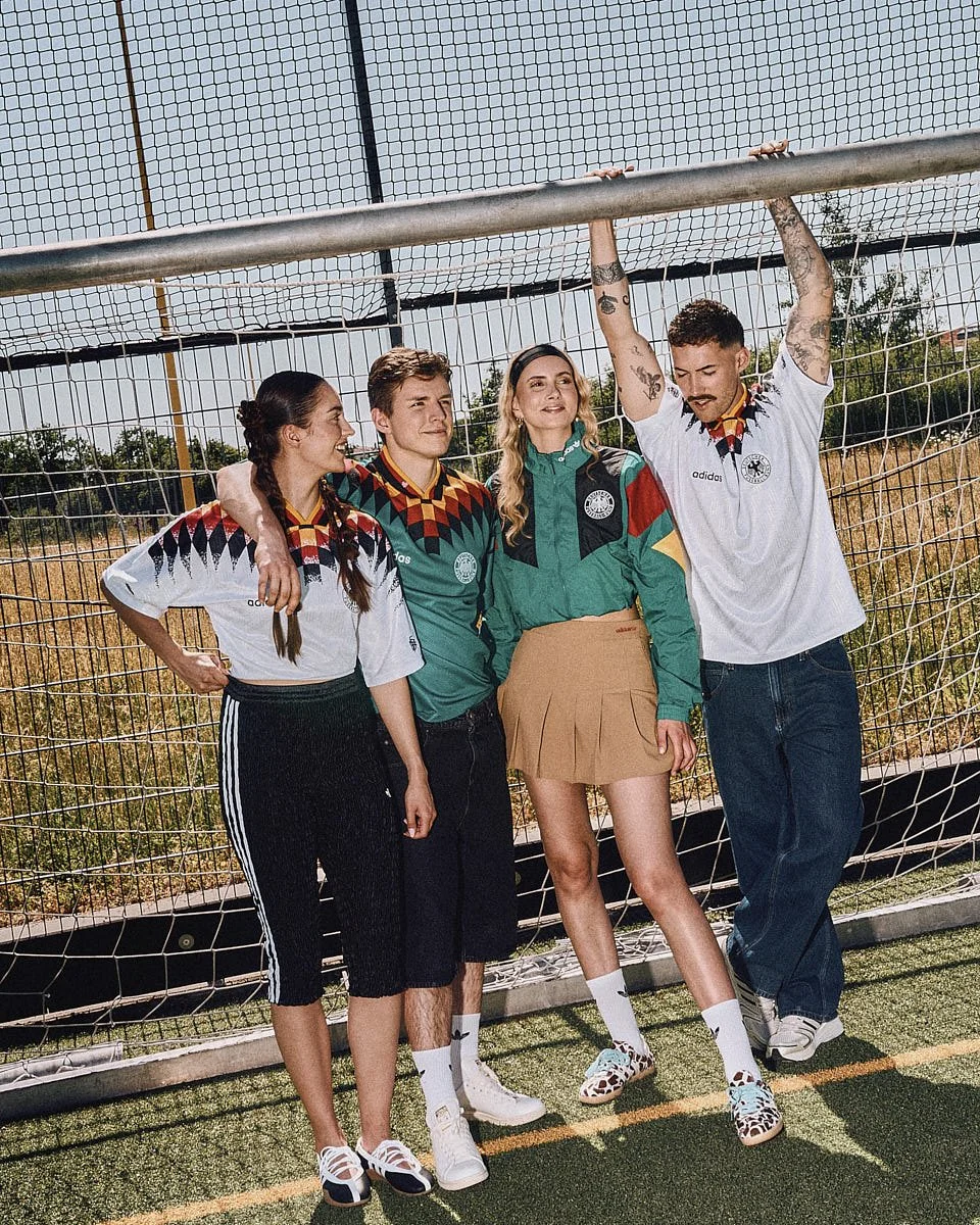 Four models wear pieces from the adidas Originals Germany EQT Bringback Collection in front of a football goal for LE MILE Magazine