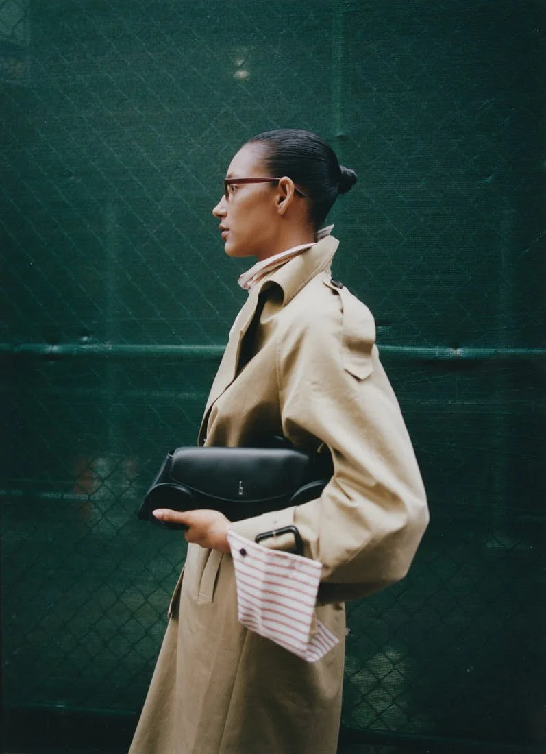 CHRIS SAULNIER LE MILE Magazine NYC WINTER BREATH FW25 Story Maria wears a trench coat and striped shirt by Wàngda, a bag by Behno, pants by Pence, and shoes by Femme Liberee