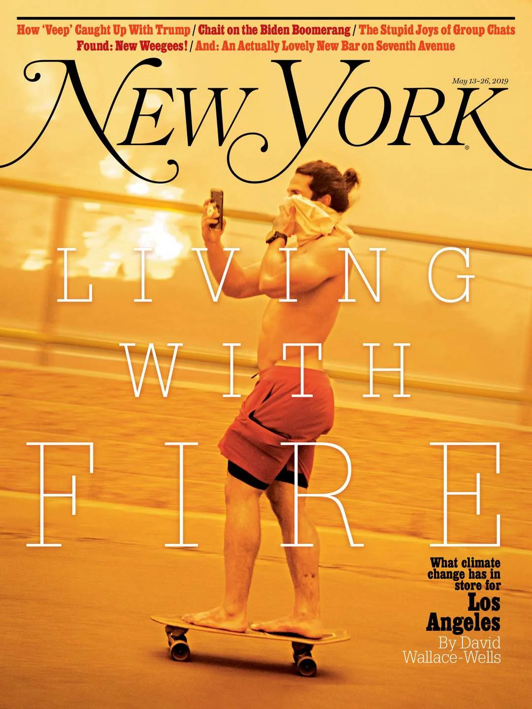 The cover of New York magazine featuring a shirtless man with long hair tied back, standing on a skateboard, taking a selfie with a phone, with orange hue lighting and a blurred background. The main headline reads "Living With the Fire" and includes a subtitle about climate change in Los Angeles.