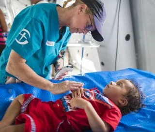 Samaritan's Purse worker attending a survivor of an Ecuadorian earthquake