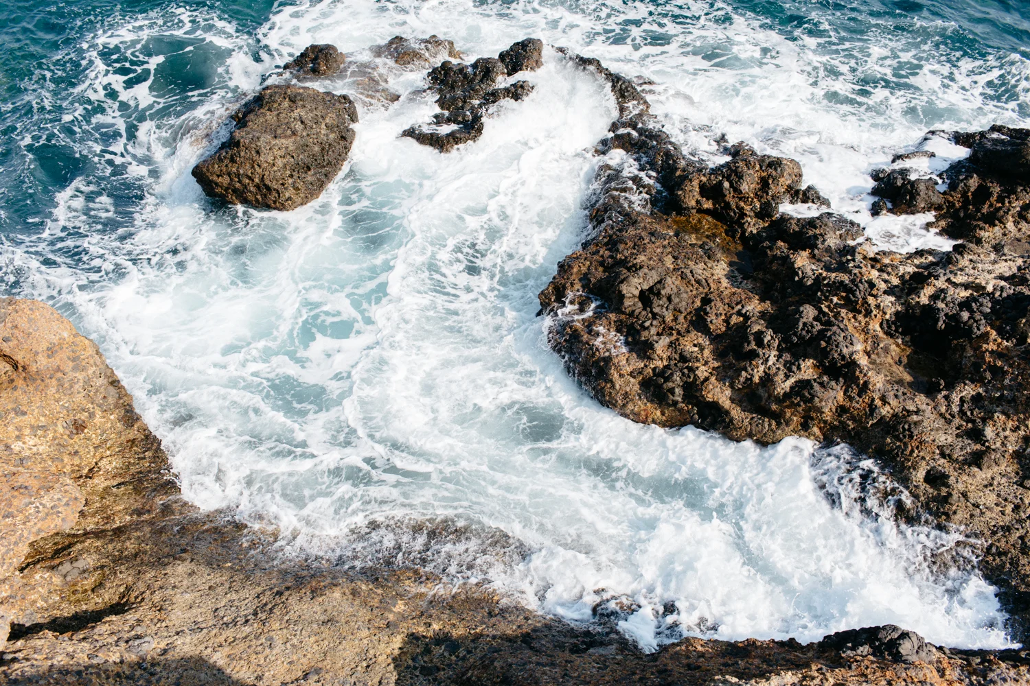 Ondas do mar batendo contra rochas na costa.