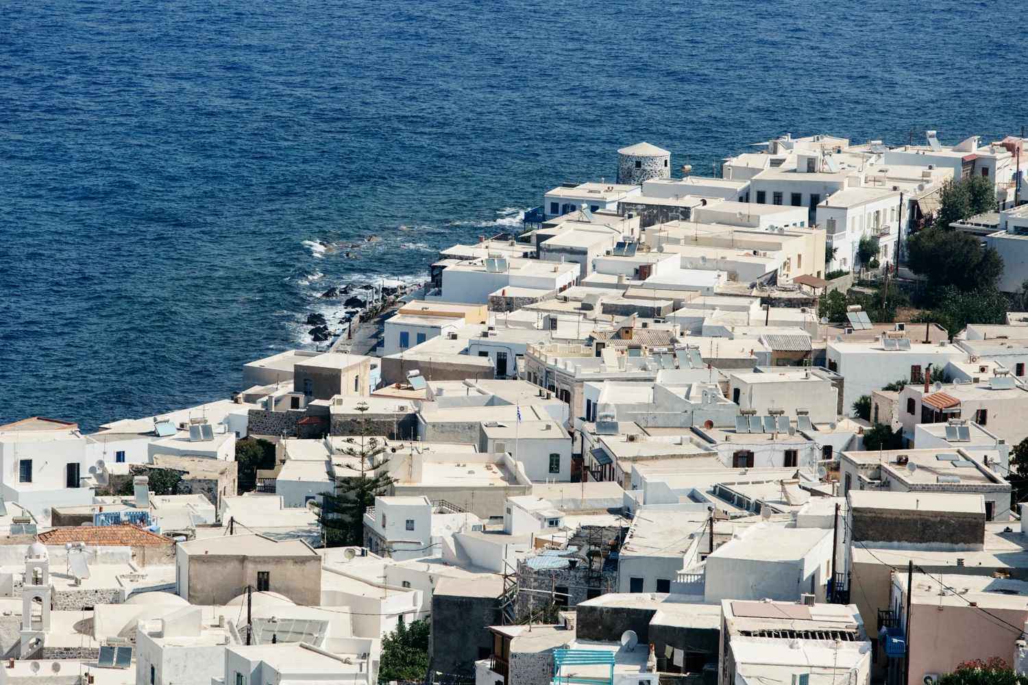 Paisagem de uma vila com casas brancas à beira-mar no mar Egeu.