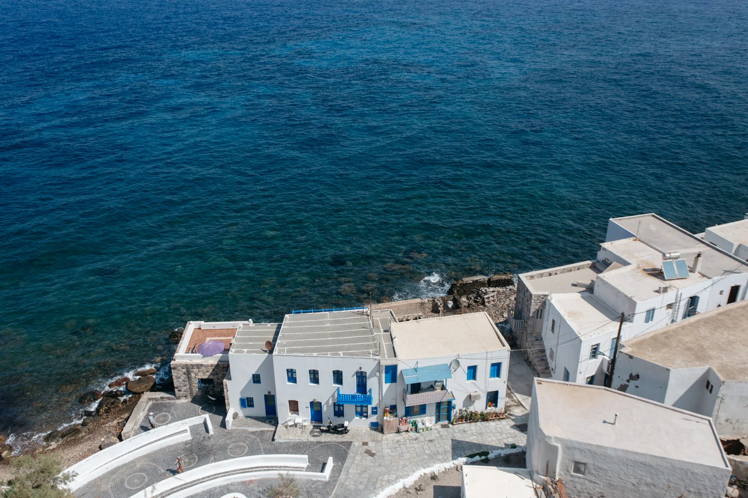 Casas brancas com detalhes em azul à beira-mar no litoral grego