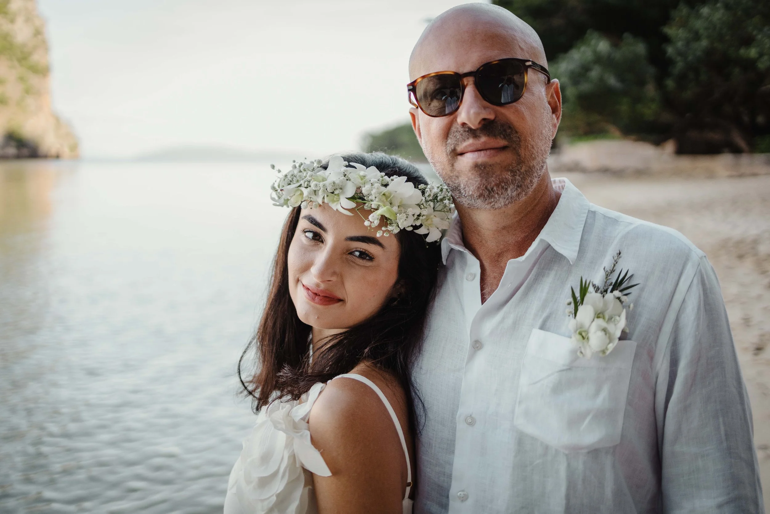 Um casal com trajes de casamento brancos iguais, juntos, irradiando alegria e amor no seu dia especial.