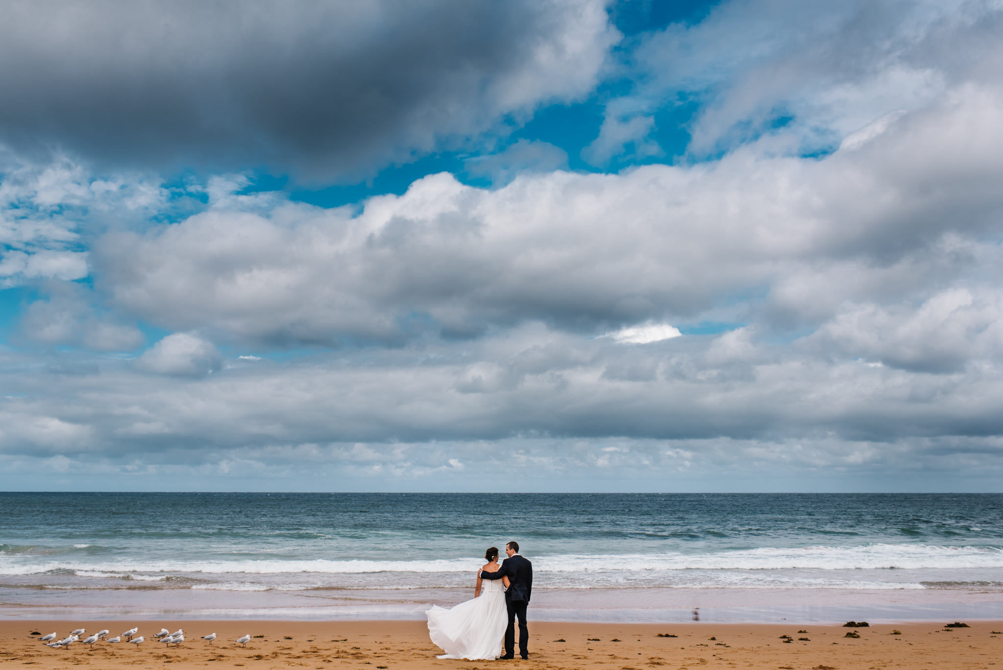 Weddings northern beaches - newlywed couple embrace on beach