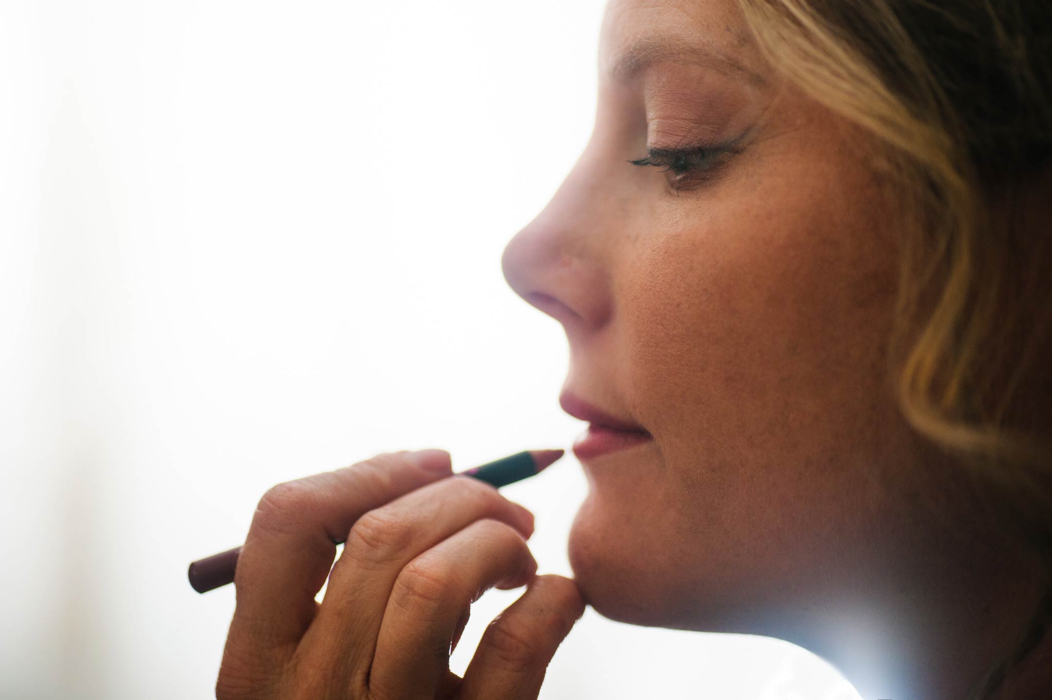 Profile of bridesmaid having makeup done