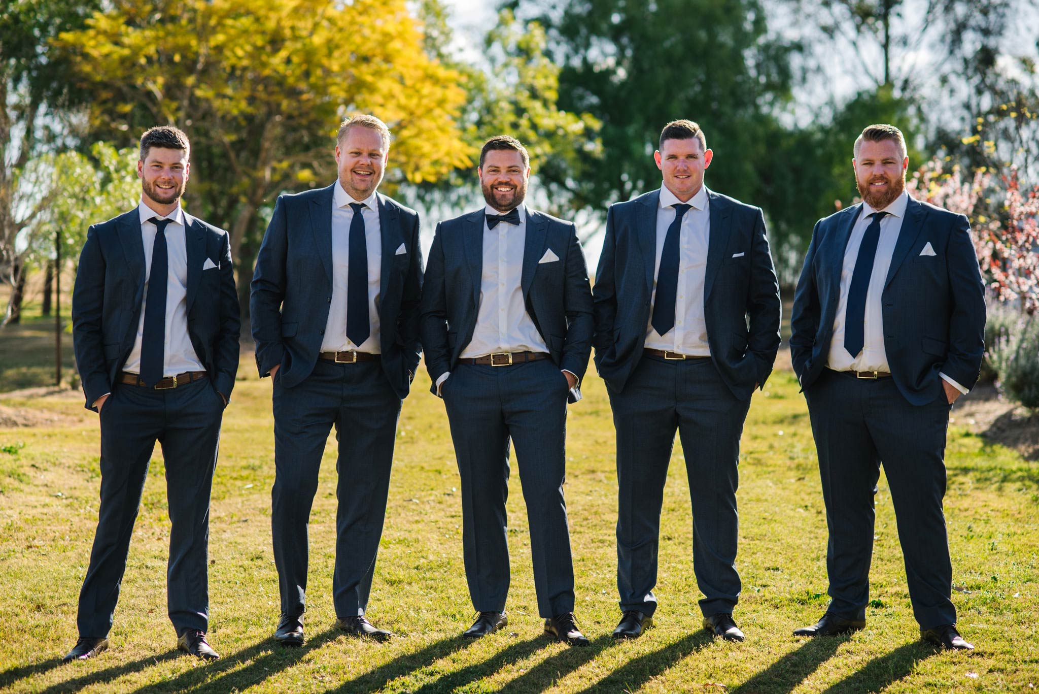 Groomsmen and groom standing in garden