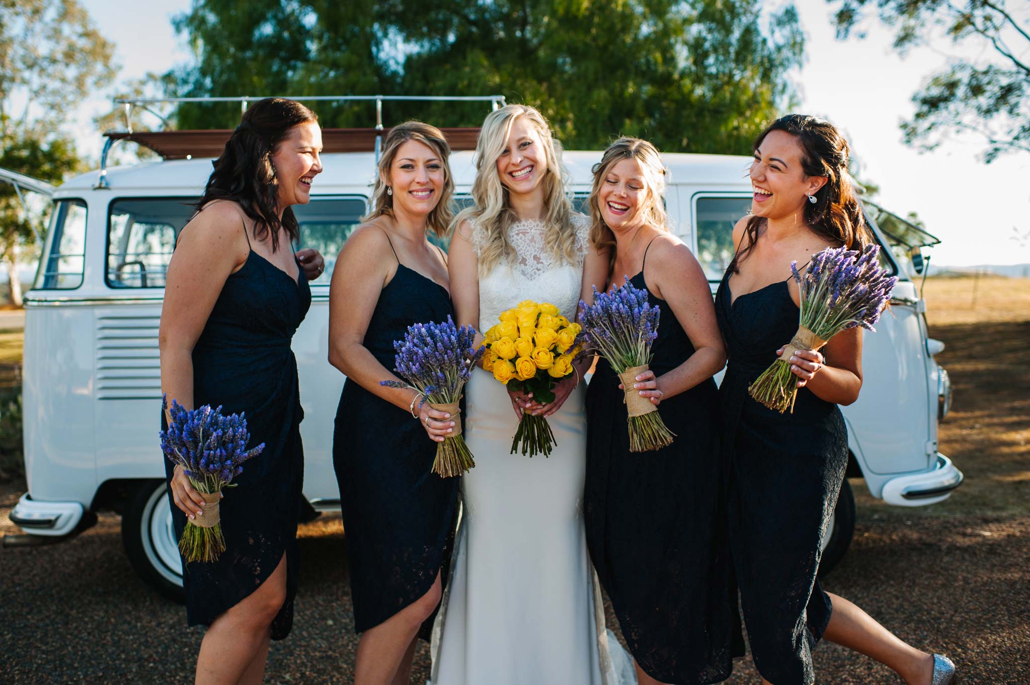 Bridesmaid and brides standing in front of a combi van