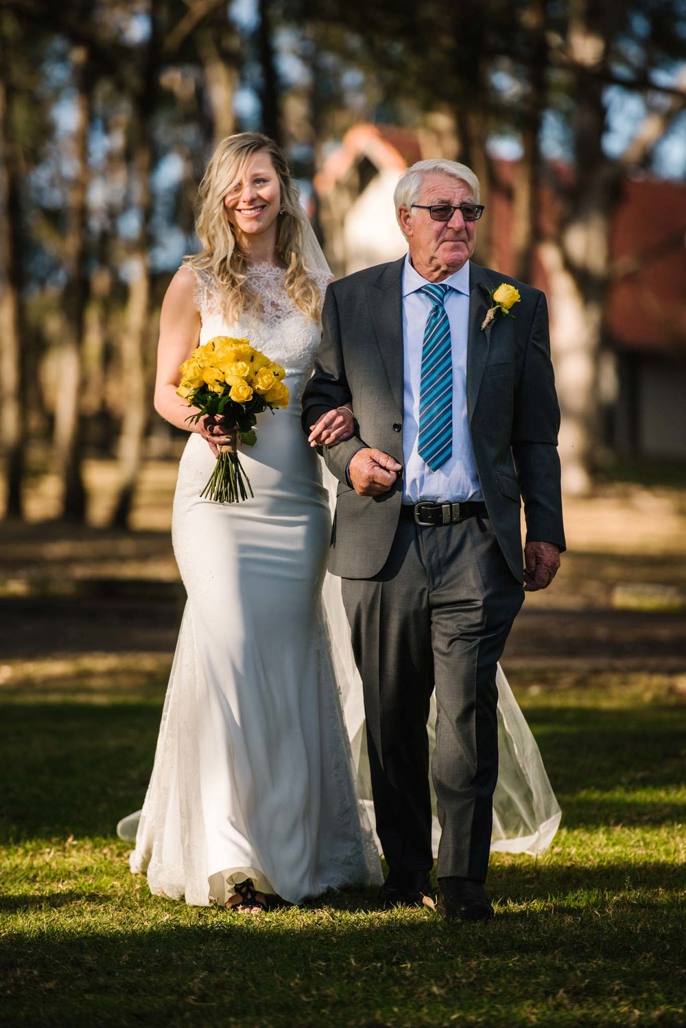 Bride and father walk down aisle during ceremony at Wandin Valley Estate