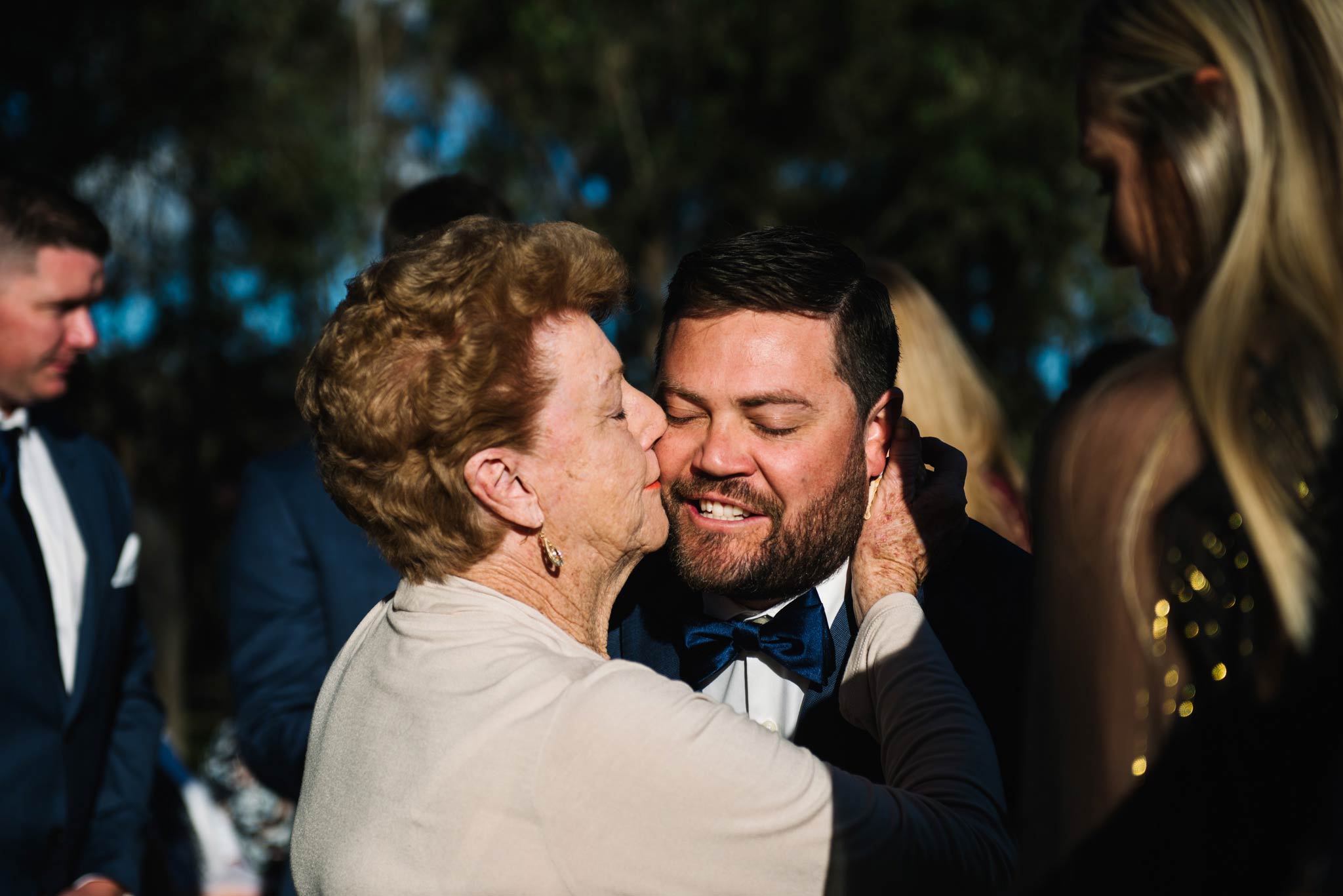 Grandma kisses groom on the cheek after wedding ceremony