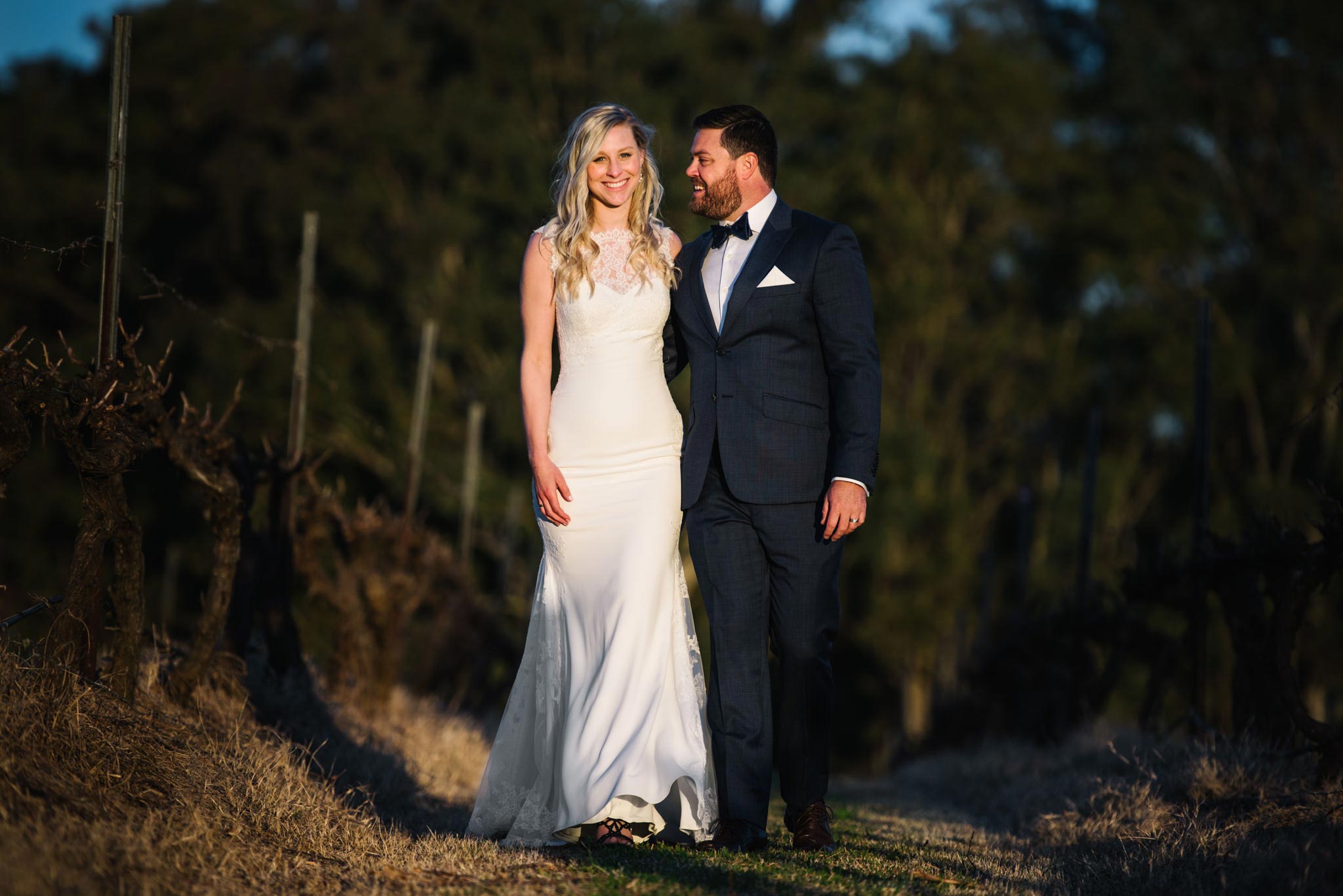 Newlyweds smiling and walking along country path