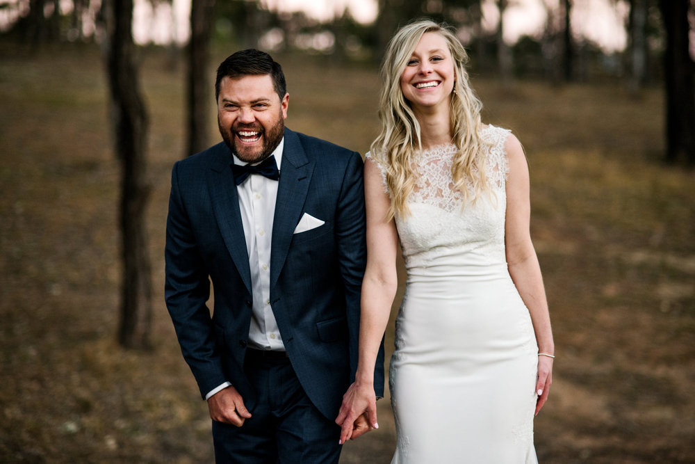 Bride and groom laughing and holding hands