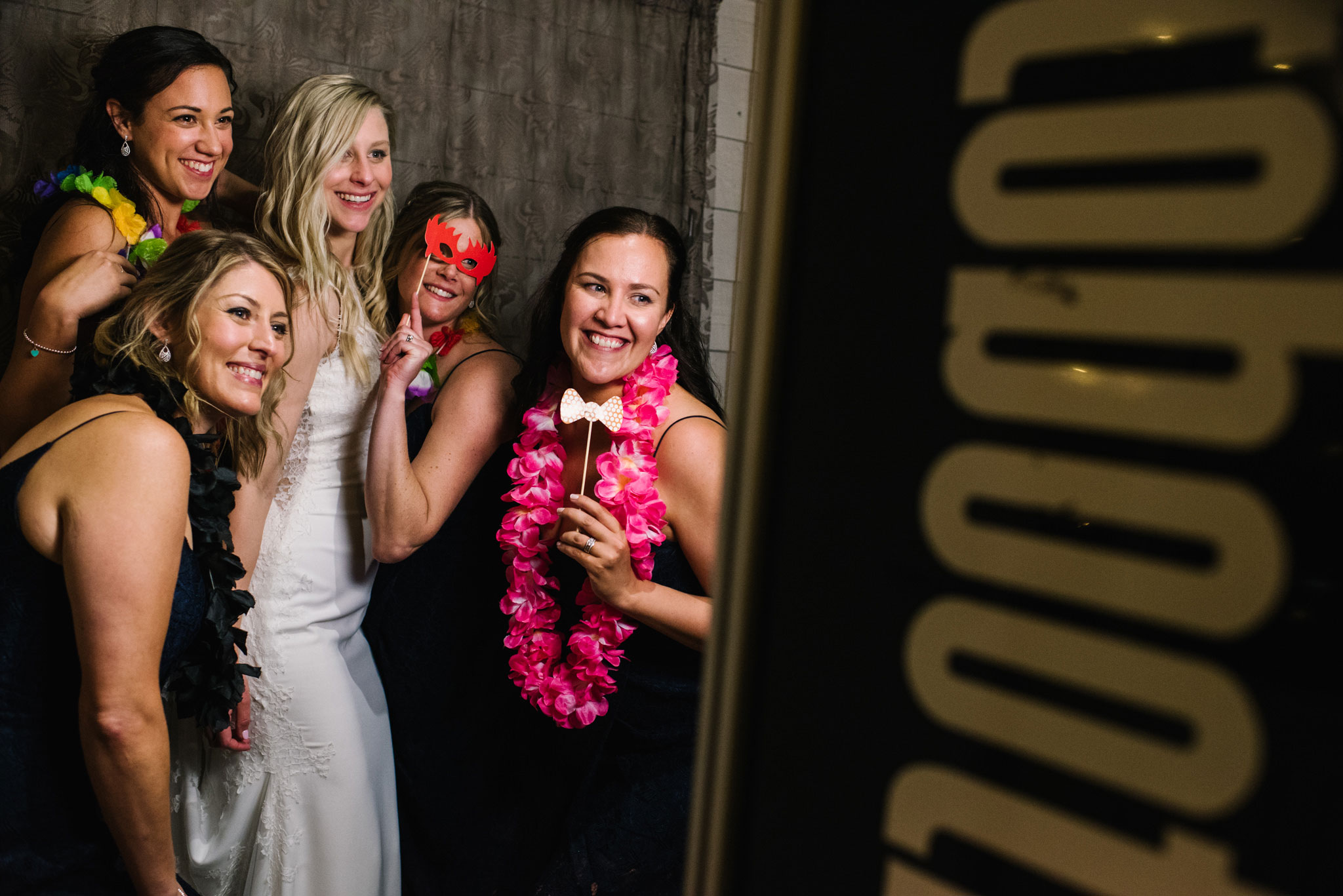 Bride and bridesmaid having fun in front of photo booth
