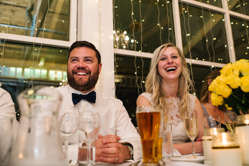 bride and groom laughing during father of the bride's speech