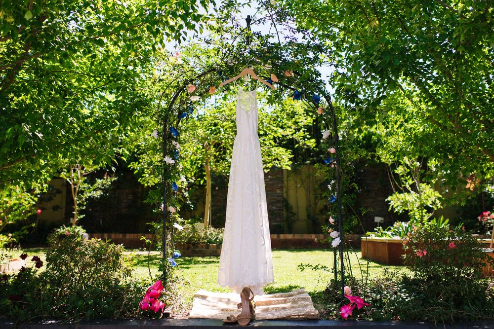 Grace Loves Lace bridal gown hanging in flowering garden