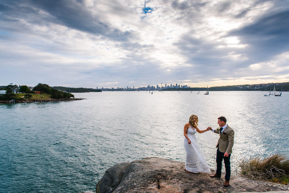 Bride and groom dance on headland at Camp Cove