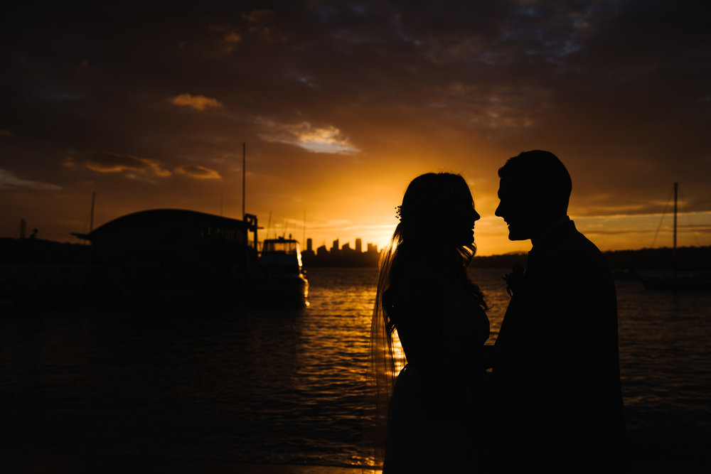 Bride and groom in front of amazing sunset at Watsons Bay Wharf