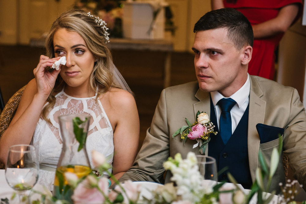 Bride wiping tears away during father's speech