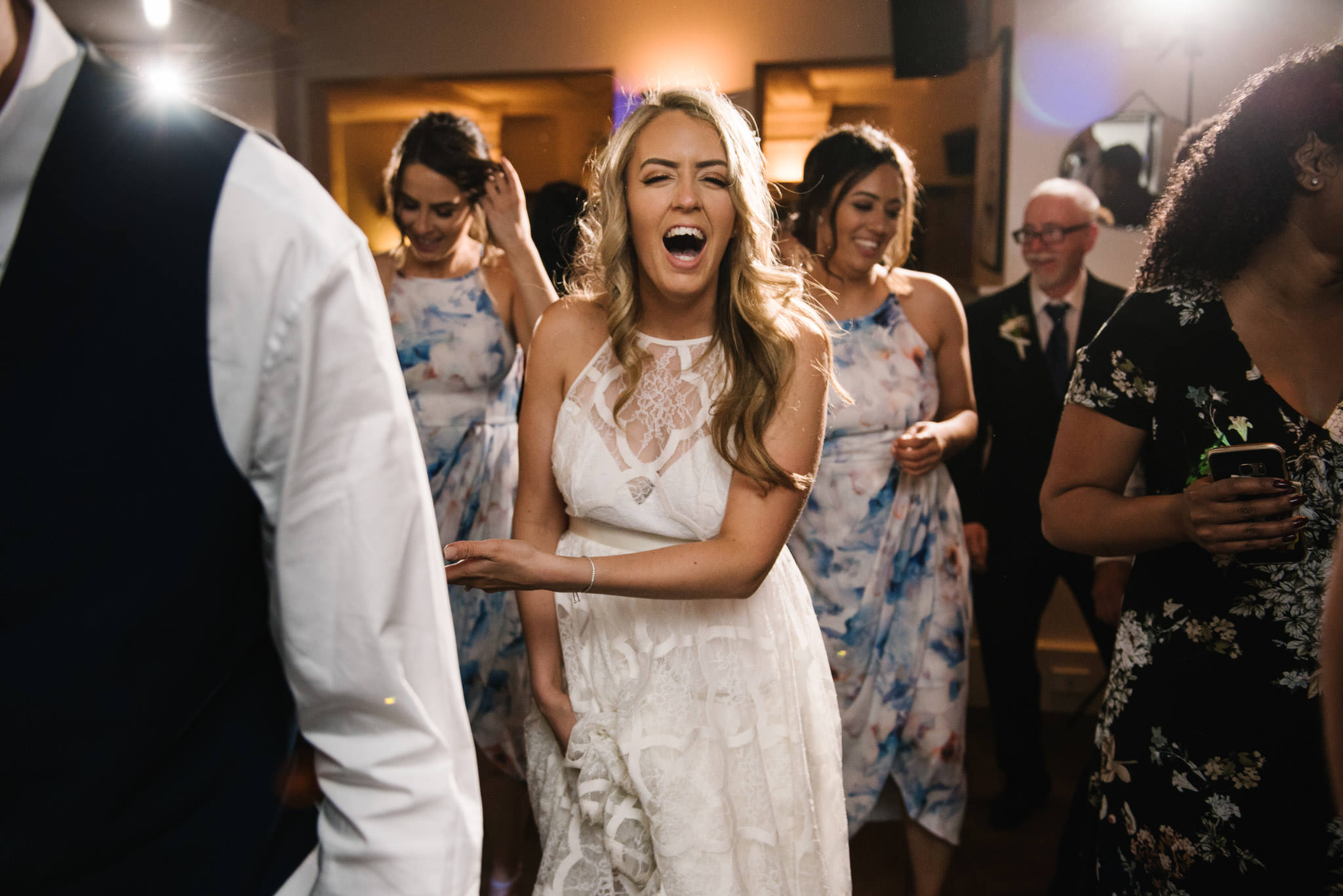 Bride laughing during line dance at wedding reception