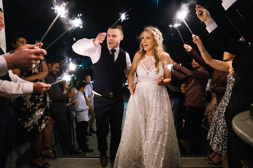 Bride and groom laughing during sparkler exit