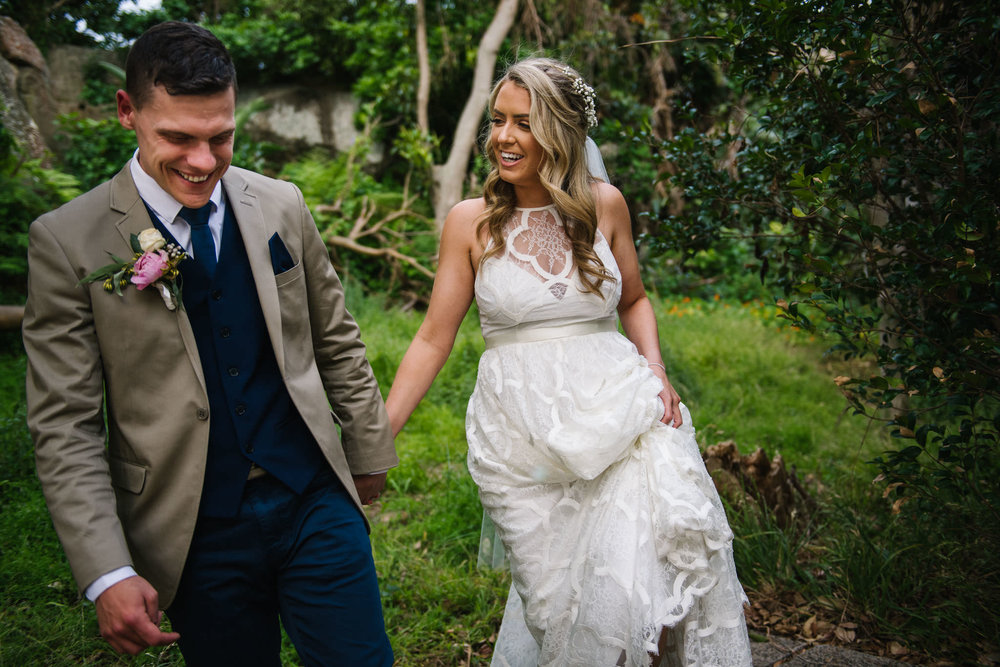 Bride and groom walking through a field