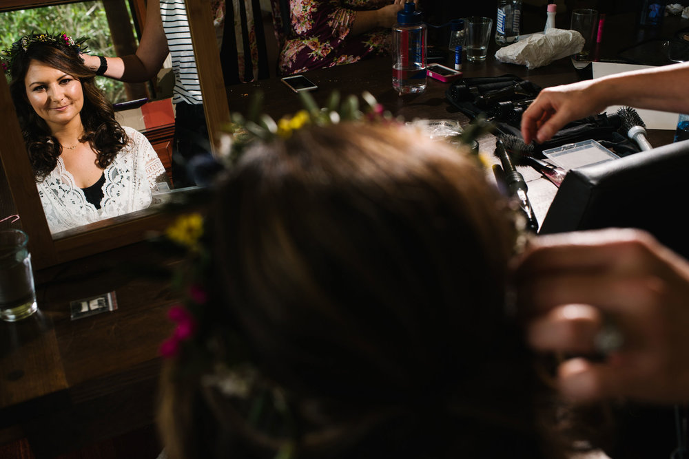 Bride looking in mirror during makeup application 
