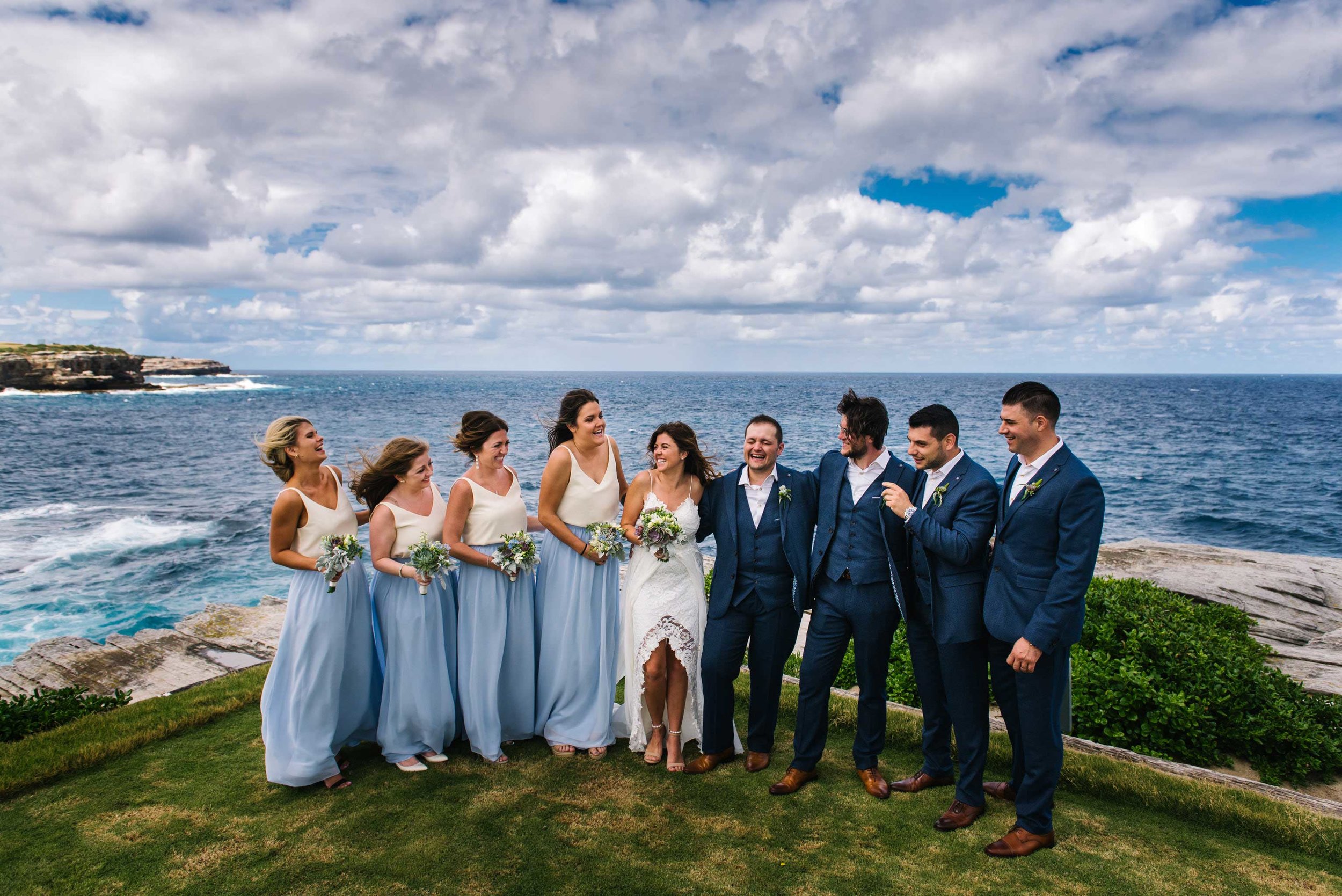 Bridal party laughing with Sydney coastline in the background