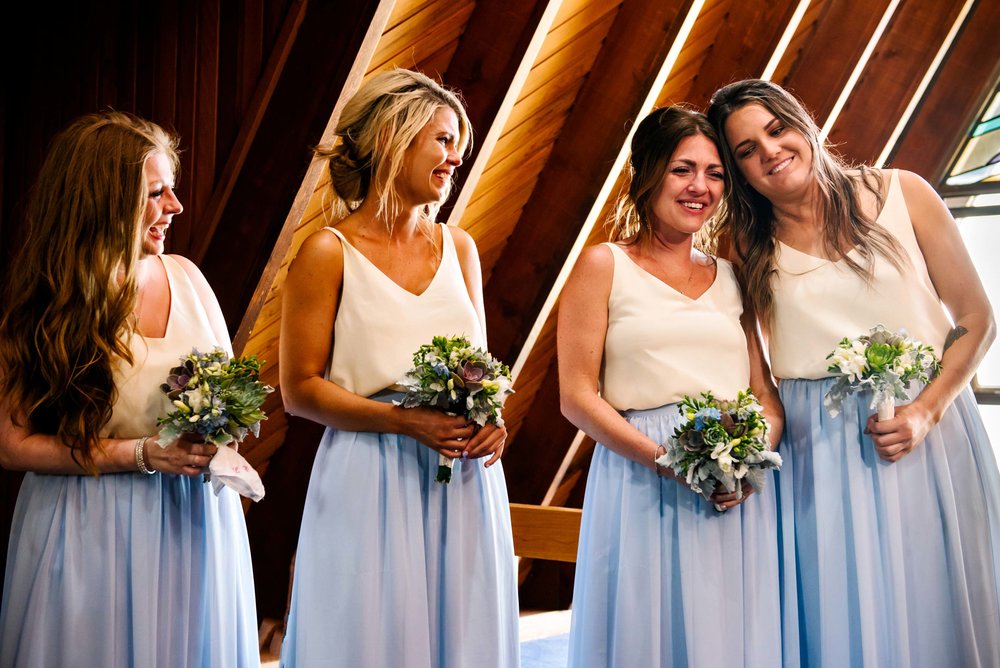 Bridesmaids looking emotional during wedding ceremony