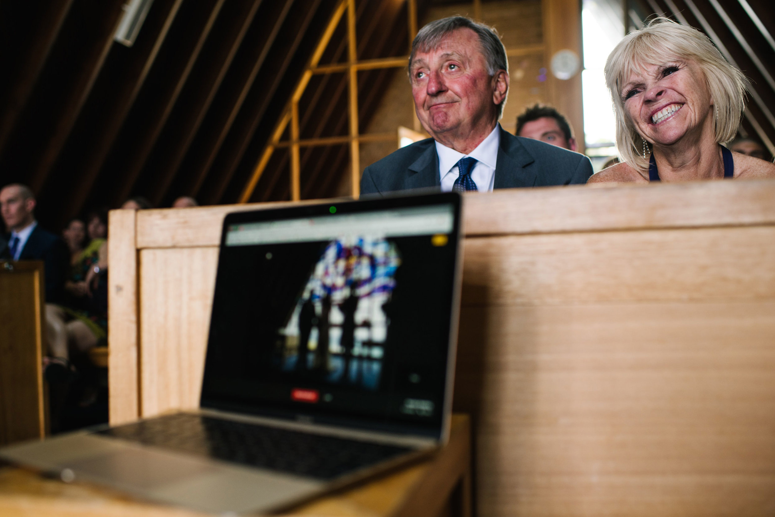 Parents of the bride smile as they watch wedding ceremony